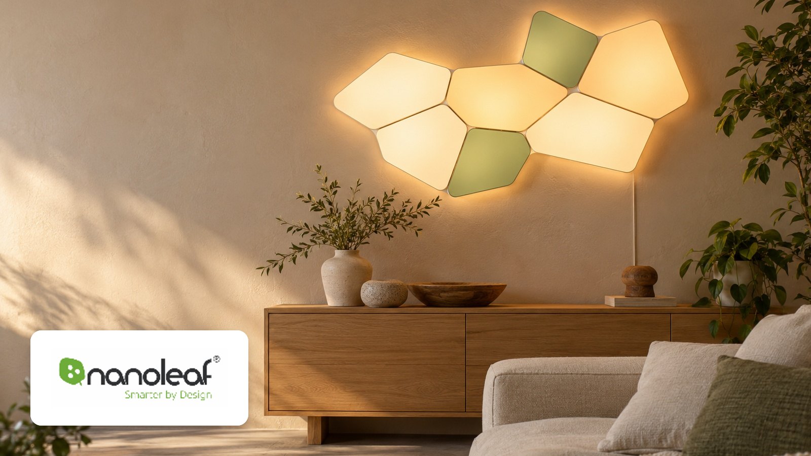 Nanoleaf logo with Seven joined geometric light panels glowing on a plaster wall above a wood sideboard